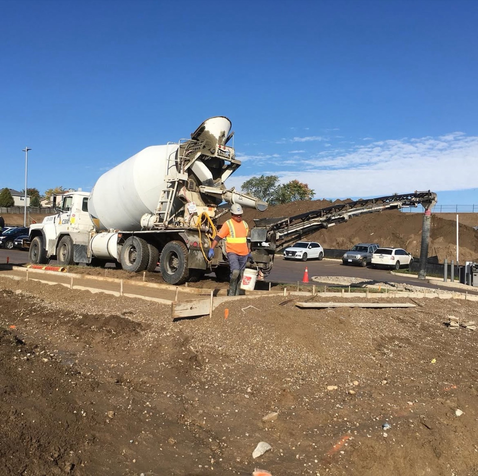 Conveyor placing concrete into sidewalk forms
